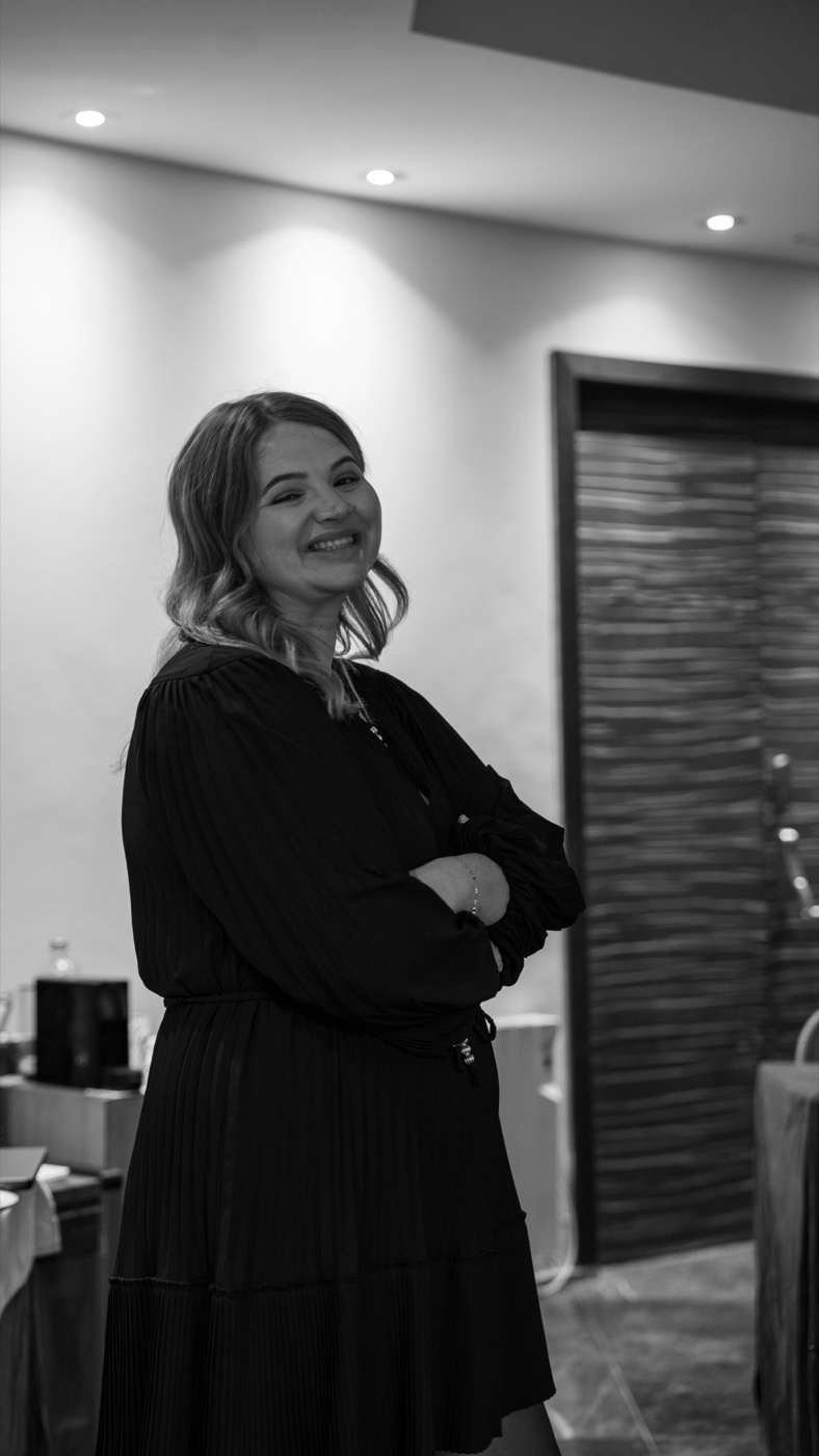 Black and white portrait of Agata Andryszczak smiling, arms folded